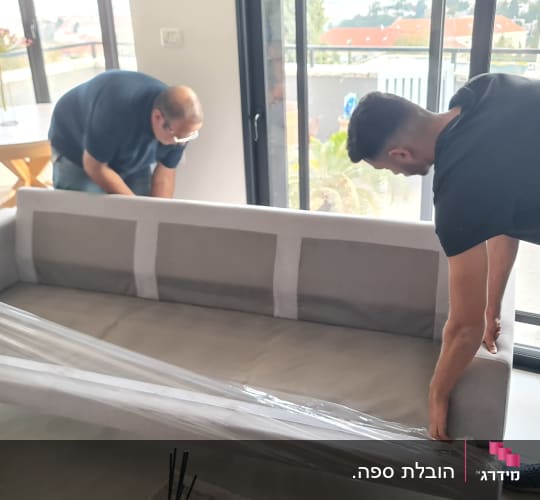 שני אנשים עוטפים ספה בניילון לקראת מעבר דירה